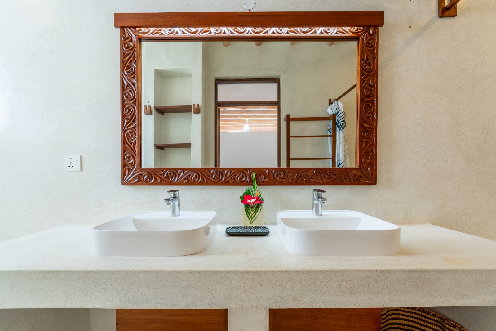 Double washbasins and carved wooden mirror